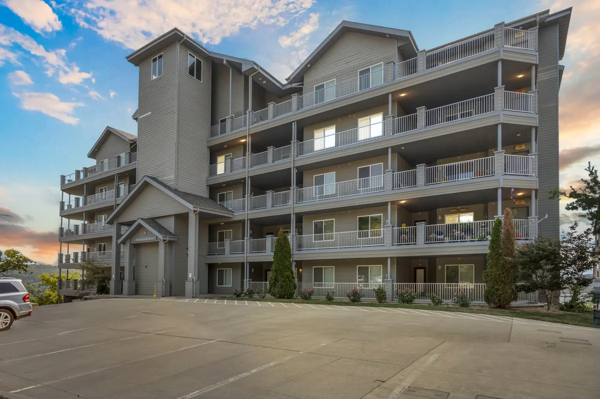 A serene exterior shot featuring balconies, an inviting entrance, and landscaped garden areas. The scene invites exploration and relaxation, with sunset light and a peaceful ambiance suggesting opportunities for evening strolls or quiet reflection.